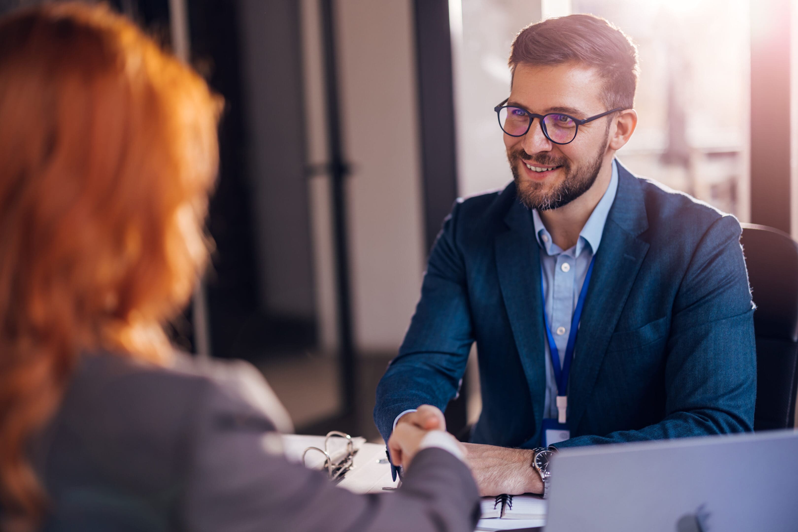 Happy bank manager shaking hands with a client after successful agreement in the office. Happy bank manager shaking hands with a client after successful agreement in the office.