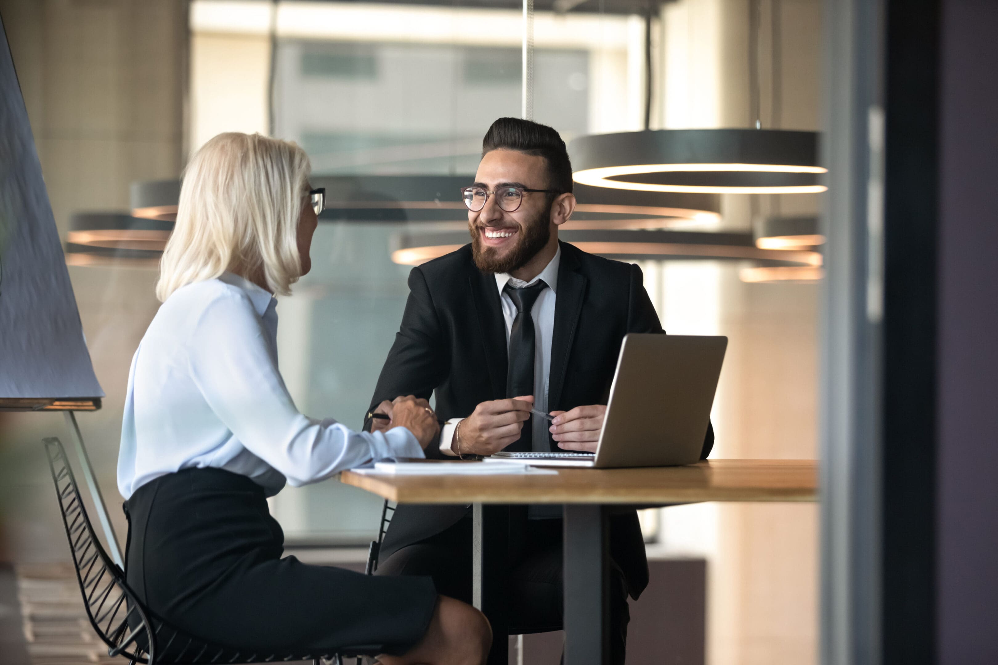 European Arabian business partners negotiating sit at desk during meeting European Arabian business partners negotiating sit at desk hold pens pc notepads on table, diverse client and boss meet for solve issues, plan future cooperation, making profitable proposition concept